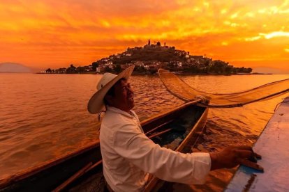 Un pescador michoacano sonríe sobre su balsa en el Lago de Pátzcuaro, Michoacán.